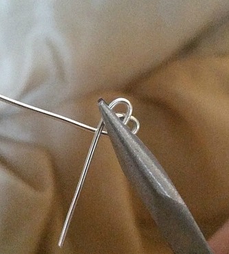 Use flat pliers to hold wire heart ring