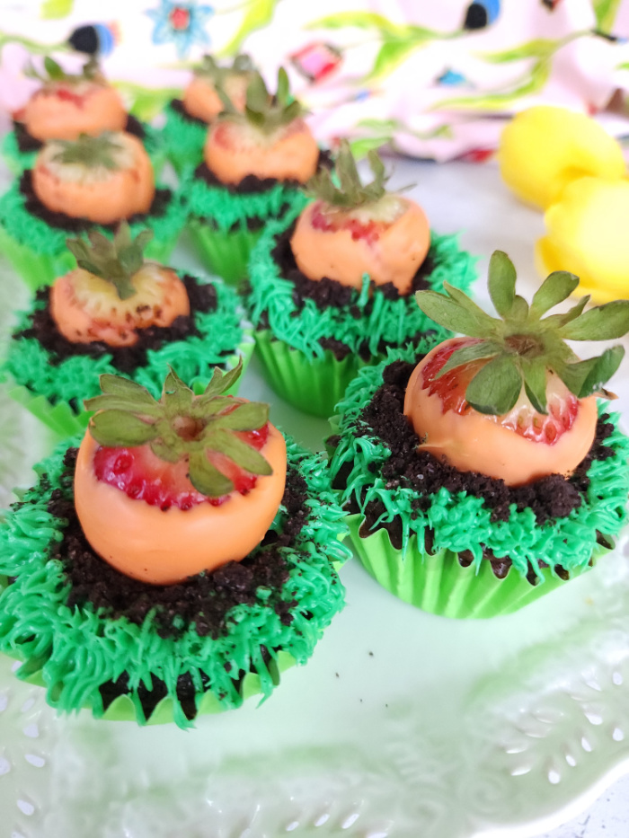 Carrot patch cupcakes on white plate.
