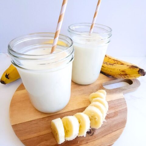 Korean banana milk in glass mason jar cups.