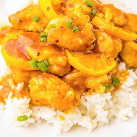 Orange Chicken over rice on a white plate.